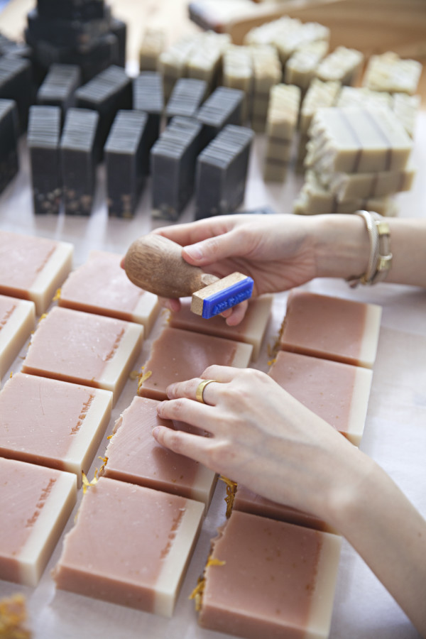 Etsy Design Award winner Mei Ong from Vice and Velvet hand-stamping each handmade soap. via WeeBirdy.com.