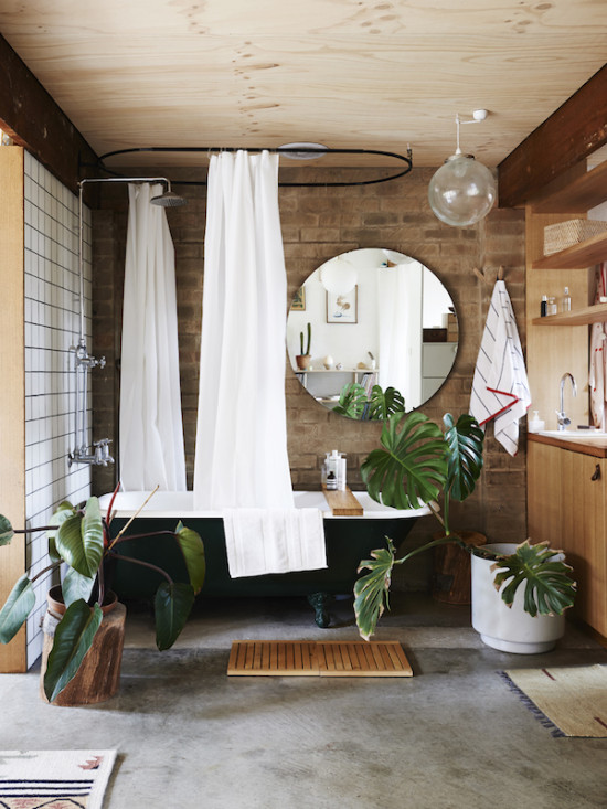 Monsteras in pots combine with a clawfoot bath in this gorgeous bathroom. Photo by Eve Wilson for The Design Files. 