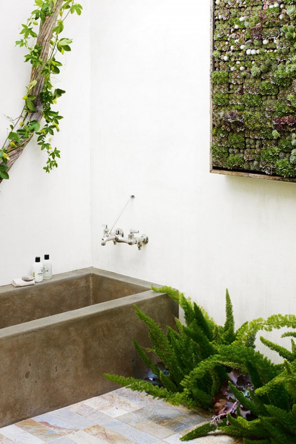 This bathroom is all about texture. A vertical wall of succulents combine with ferns and a twisted vine to contrast against the concrete bathtub. Photo by Jen Siska for Flora Grubb Gardens via Inside Out.
