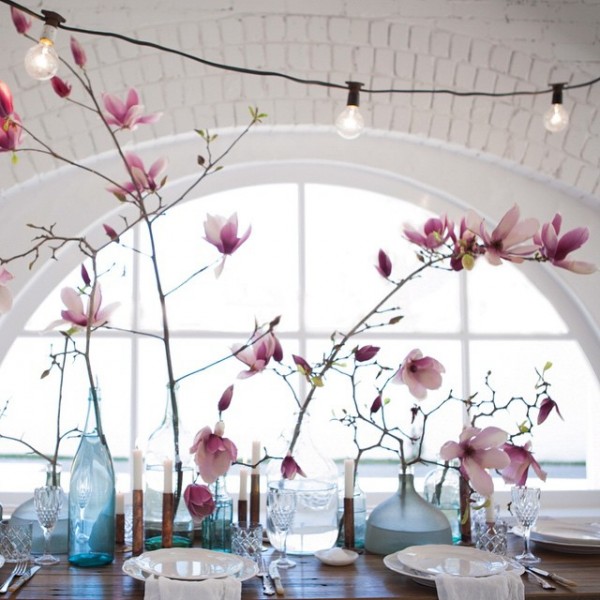 Magnolias and string lights combine for a pretty table setting, via The Lane.