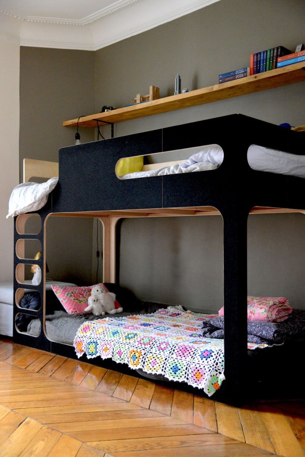 A matt black bunk bed makes smart choice for a shared space, with the girl's lower bed decorated with toys and a crochet quilt, while the boy's upper bunk is decorated with his favourite colours, via vanessapouzet.