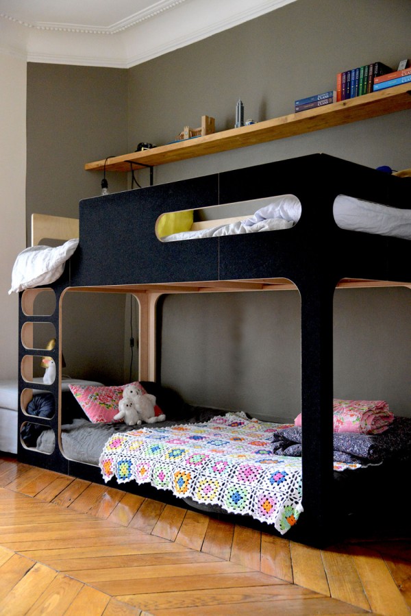 A matt black bunk bed makes smart choice for a shared space, with the girl's lower bed decorated with toys and a crochet quilt, while the boy's upper bunk is decorated with his favourite colours, via vanessapouzet. 