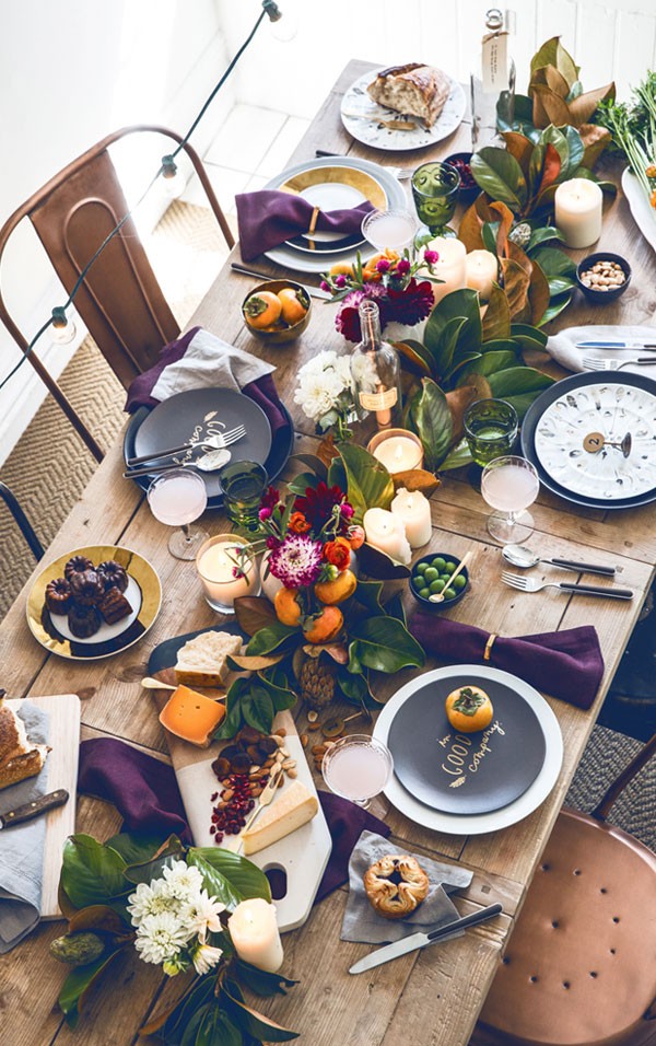 Persimmons and magnolia leaves make a colour match in heaven in this tabletop via Apartment 34.